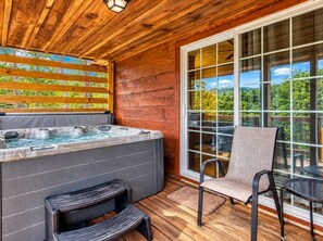 A wooden deck with a hot tub, outdoor seating, and a view of the forest. - Rivers Ridge & Guest House - New Listing (Sevierville)
