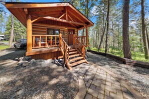 A log cabin with a porch, wooden stairs, and a gravel driveway. - Moose Hollow Studio Cabin (Eureka)