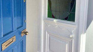 Eine blaue Tür mit weißem Zierrahmen und einem Fenster mit dekorativem Muster.