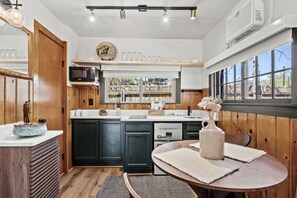 A kitchen with wooden cabinets, a sink, and a window with a view. - Trailside Cabin Escape with Stunning Views and Easy Adventure Access in Colorado Springs, Colorado (Colorado Springs)