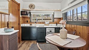 Une cuisine avec des meubles de rangement en bois, un évier et une fenêtre donnant sur un beau paysage.