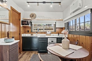 A kitchen with wooden cabinets, a sink, and a window with a view. - Trailside Cabin Escape with Stunning Views and Easy Adventure Access in Colorado Springs, Colorado (Colorado Springs)