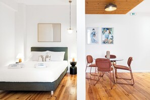 Une chambre d’hôtel avec un lit, des tables de chevet et des œuvres d’art accrochées au mur.