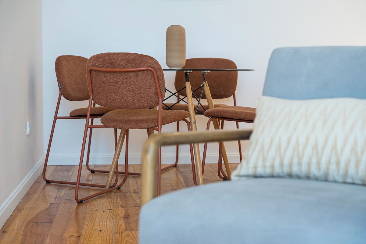 A room with a bed, a chair, and a small table.