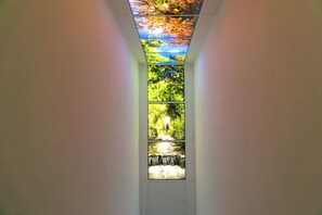 A corridor with a series of windows displaying outdoor scenes. - Haus am Krähenbach-Steinert | Wellness rental near Lake Sorpe with sauna & WiFi (Sundern (Sauerland))