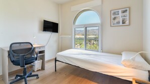 A bedroom with a bed, a desk with a chair, a TV mounted on the wall, and a window with a view. - Vacation Home 'Bellavista Los Pinos' with Mountain Views, Private Terrace and Wi-Fi (Almuñécar)