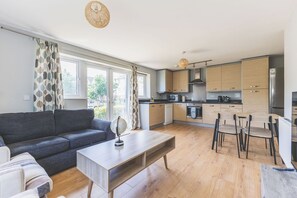 Een modern appartement met een woonkamer, een eetgedeelte en een keuken.