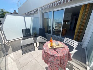 A patio with a table set for two, a bottle, and a bowl. - ATLANTIQUE 4 - Studio sea view in holiday rental in Carnac, Morbihan - UAT26 (Carnac)