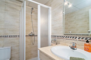 A bathroom with a shower, toilet, sink, and a mirror. - Vibrant Golf Valley Apartment with Terrace and Three Pools (Marbella)