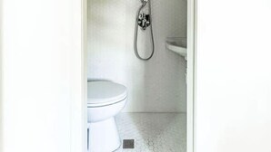 Un baño con inodoro, ducha y lavamanos.