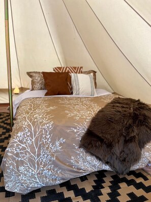 A tent with a bed, pillows, and a blanket. - Boho Bell Tent Glamping in Swan Valley, Idaho near Jackson Hole (Irwin)