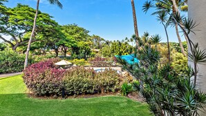 A lush garden with palm trees, a pool, and a gazebo. - Tropical Retreat, steps from Charlie Young Beach (Kihei)