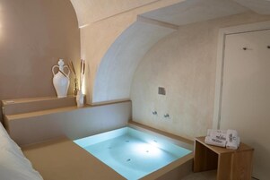 Un bagno moderno con una vasca freestanding, un porta asciugamani e un piccolo sgabello di legno.