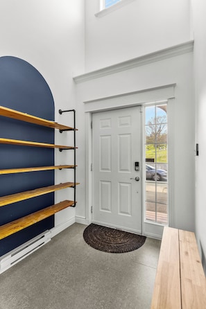 A room with a white door, a blue wall, and a wooden bench. - BLVD QV Lake House  4BR  Backyard  Pets  Parking (St. John's)
