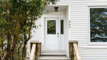 A white house with a stone staircase leading to a white door marked with the number 397.