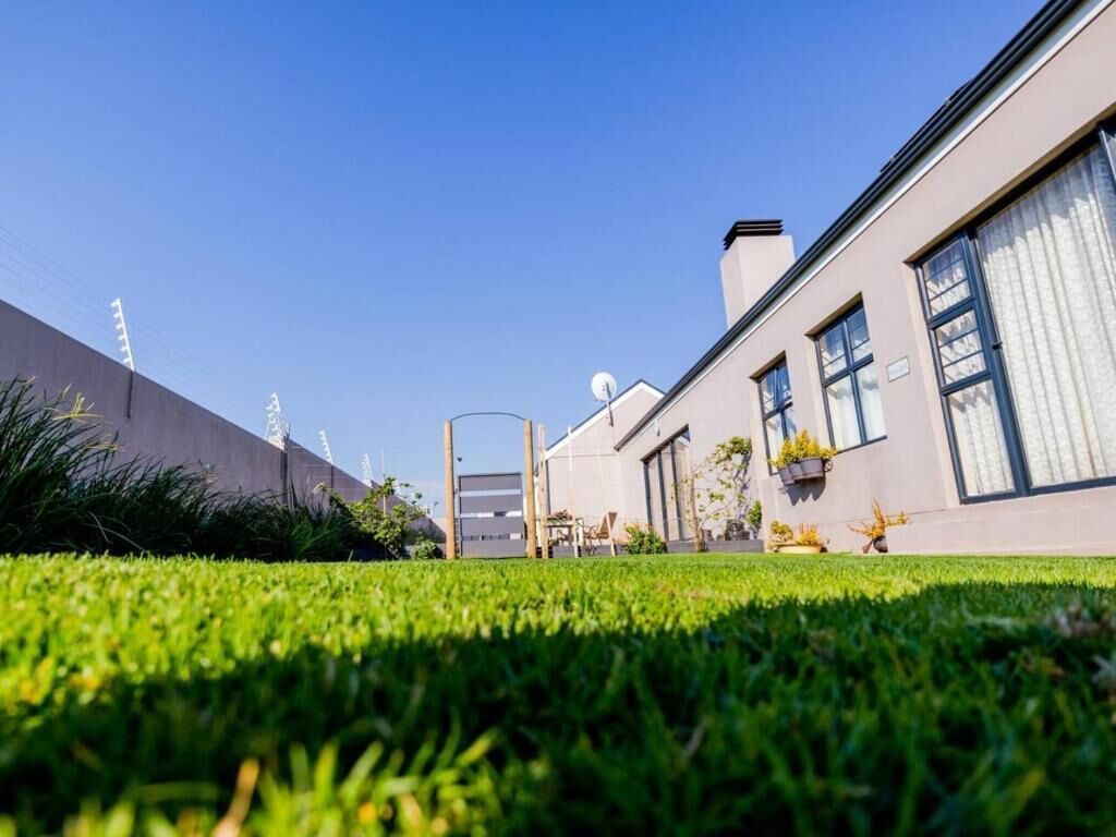 A modern building with a flat roof, large windows, and a well-maintained lawn. - Worcester the Karoo Guestrooms (Altona, Worcester)