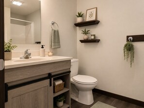 A bathroom with a white sink, a toilet, and wooden shelves with plants and baskets.