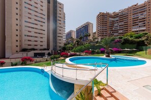 A residential area with a swimming pool, surrounded by high-rise buildings and lush greenery. - VILA PARK relax apartment (La Vila Joiosa)