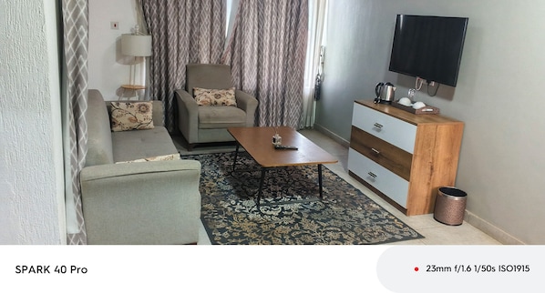 Suite estudio junior, vista a la ciudad | Área de sala de estar