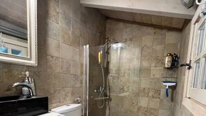 A bathroom with a toilet, a shower, a sink, and a mirror. - House Sleeps 6 With Pool (Chalcis)