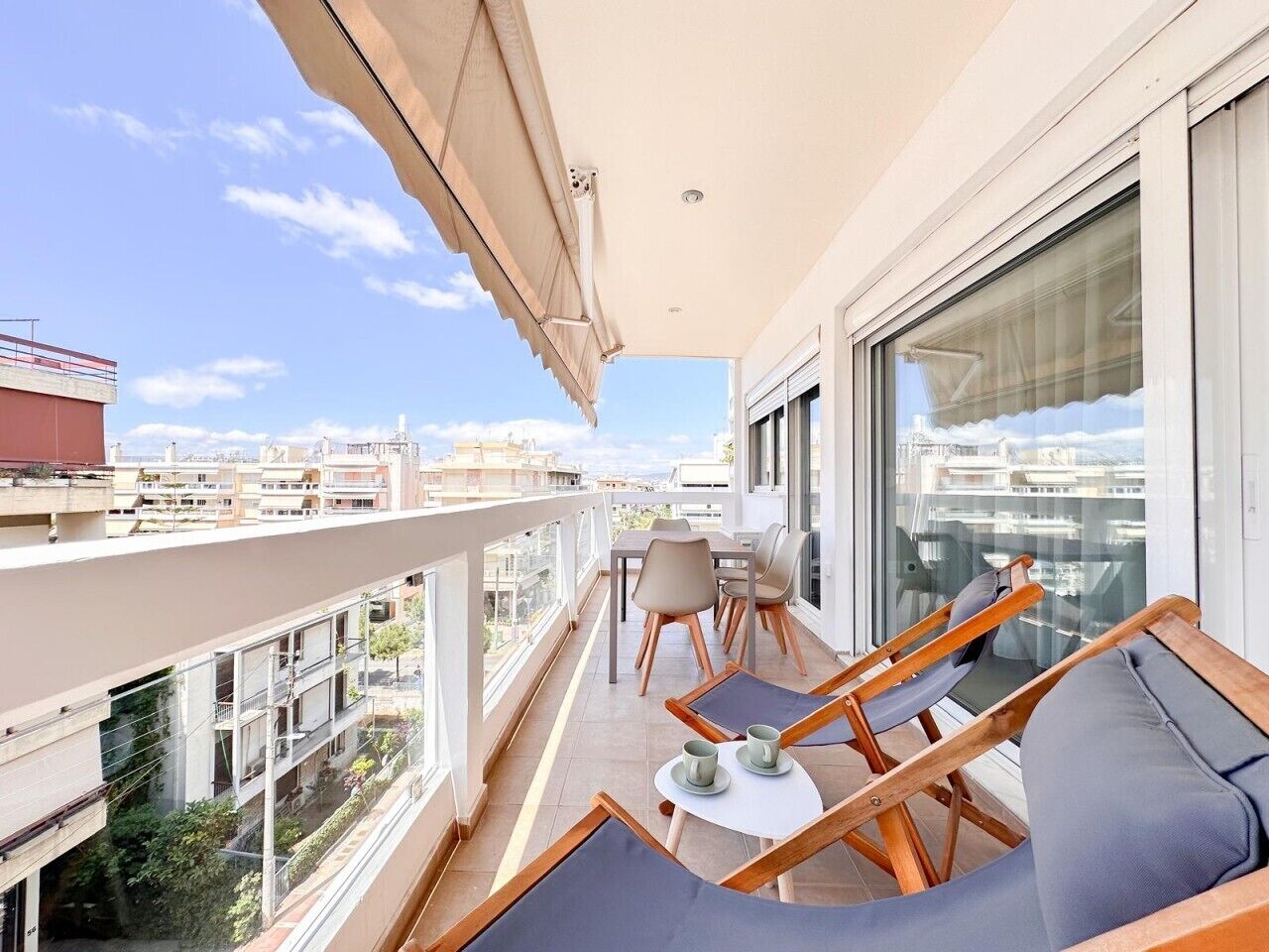 Ein Balkon mit Tisch, Stühlen und einer Couch.