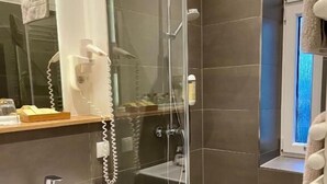 A modern bathroom with a glass-enclosed shower, a white sink, and a towel rack. - Hotel 38  (Berlin)