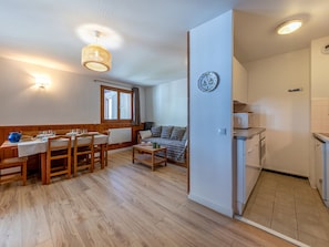 A compact living space with a dining area, a sofa, a kitchen, and a small table. - Apartment mountain view - 4 guests (Val-d'Isère)