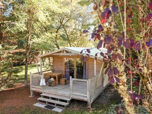 Eine Holzhütte mit Veranda, Tisch und Bank.