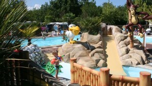 Ein Wasserpark mit Pool, Rutschen und einer Maskottchen-Figur.