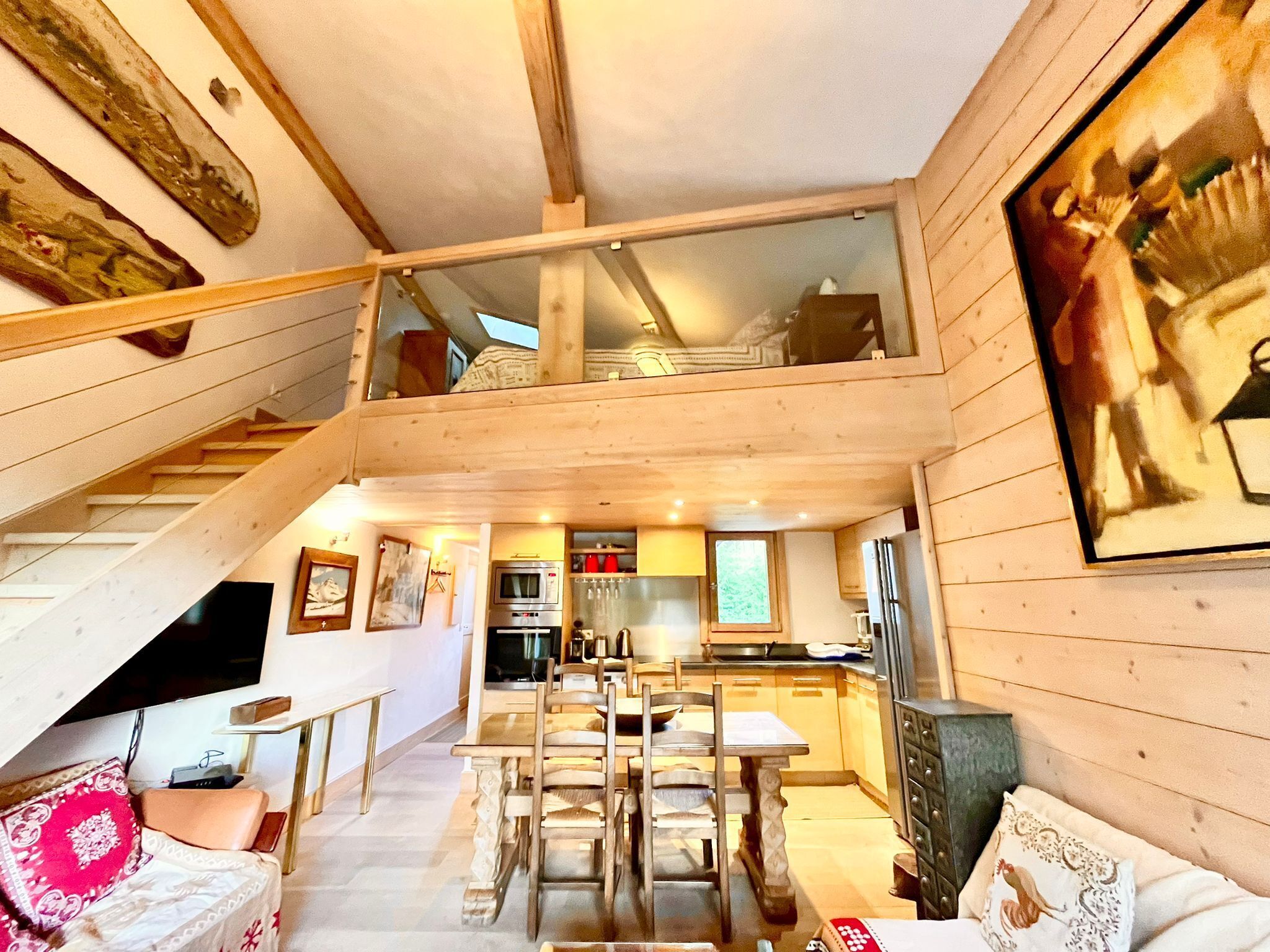 Une cabane en bois à plusieurs niveaux, comprenant un coin repas, une cuisine et un escalier.