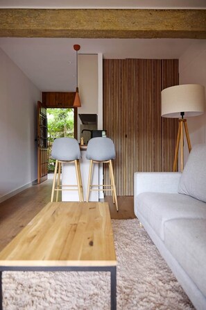 A modern living room with a wooden coffee table, two grey chairs, a white sofa, and a lamp. - La Escondida Rural (San Martín de Valdeiglesias)