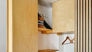 A wooden closet with multiple shelves and a hanging rod. - La Escondida Apartment at the San Juan B Reservoir (San Martín de Valdeiglesias)
