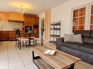 Ein modernes Wohnzimmer mit einer Couch, einem Couchtisch und einem Essbereich mit Stühlen und einem Tisch.
