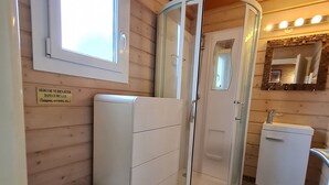 A compact bathroom with a toilet, a shower enclosure, and a sink.