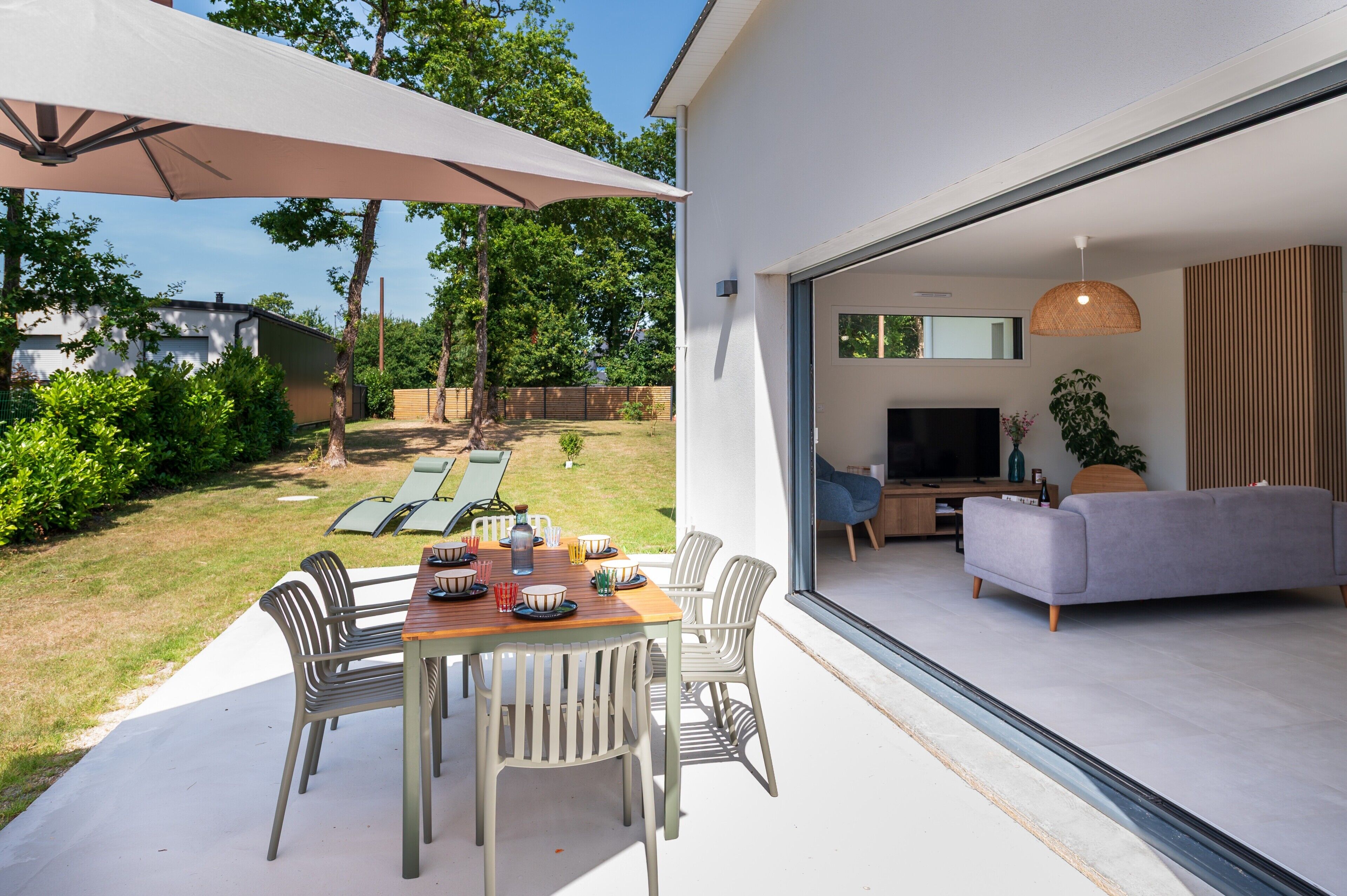 Un espace de vie à aire ouverte comprenant un téléviseur, un canapé et une table à manger avec des chaises.