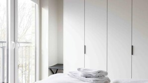 Ein Schlafzimmer mit einem Bett, einem Fenster und einem Kleiderschrank.