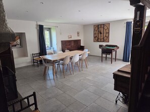A spacious dining area with a long table, several chairs, a clock on the wall, and a billiards table. - House with a garden in a renovated old farmhouse. Pets welcome! (Feigères)