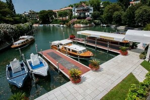 A marina with boats docked, a covered boat rental area, and buildings in the background. - Elegant Family Apartment with Terrace & Shared Garden, Steps from Lido Beach (Lido)