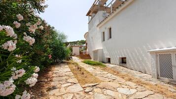 Un edificio blanco con un sendero de piedra que lleva a un conjunto de escalones.