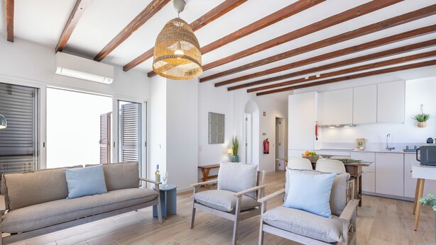 A modern living room with a sofa, chairs, a hanging light fixture, and a kitchen area with cabinets and a sink. - Alvor Arcos Beach - sun, pool and village calm (Montenegro)