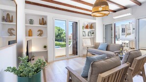 A modern living room with a sofa set, wooden beams, and a large window. - Alvor Arcos Beach - sun, pool and village calm (Montenegro)