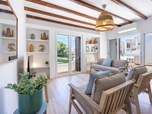 Ein modernes Wohnzimmer mit einer Sofagarnitur, Holzbalken und einem großen Fenster.