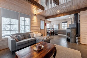 A spacious living area with a sofa, coffee table, and a fireplace. - Cozy Cabin Retreat in Riihivuori (Muurame)