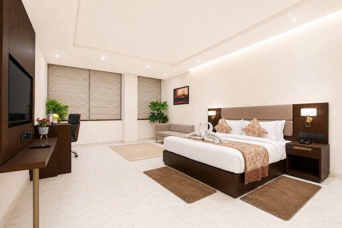 Una habitación de hotel moderna con una cama grande, un escritorio, un televisor y vistas a la ciudad.