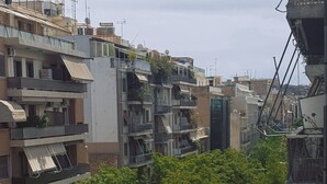 A balcony with a vase of flowers, overlooking a street with parked cars and buildings. - Athens Acropolis View Balcony 2 Min to Metro (Athina)