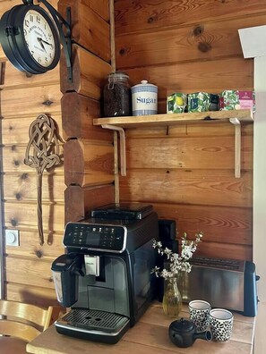 A coffee machine, a clock, and shelves with jars and boxes.