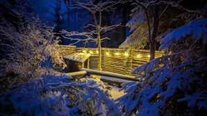 A snow-covered outdoor area with a wooden structure and a metal fence.