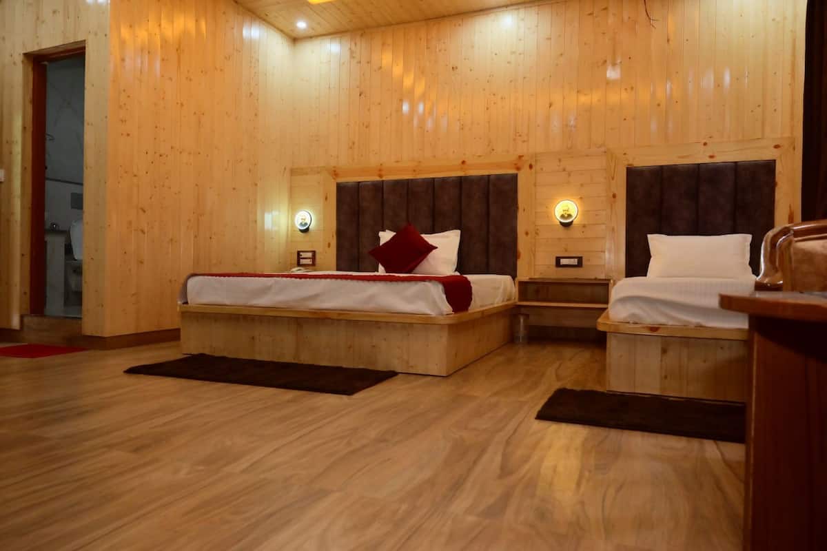 A wooden room with two beds, a small table, and a bench.