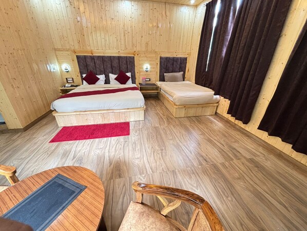 A wooden-paneled room with two beds, a small table, and a chair.