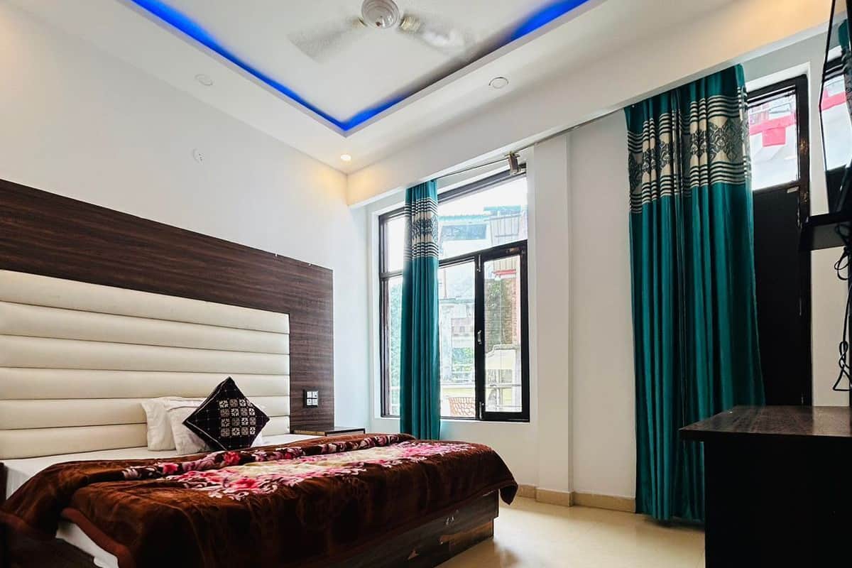 A modern bedroom with a large bed, a ceiling fan, and a desk.